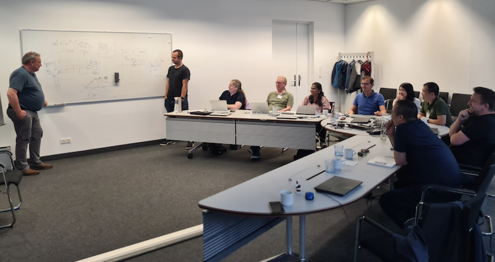 Photo of SmartEdge participants brainstorming in front of a white board, at a Technical meeting in Munich, September 2023